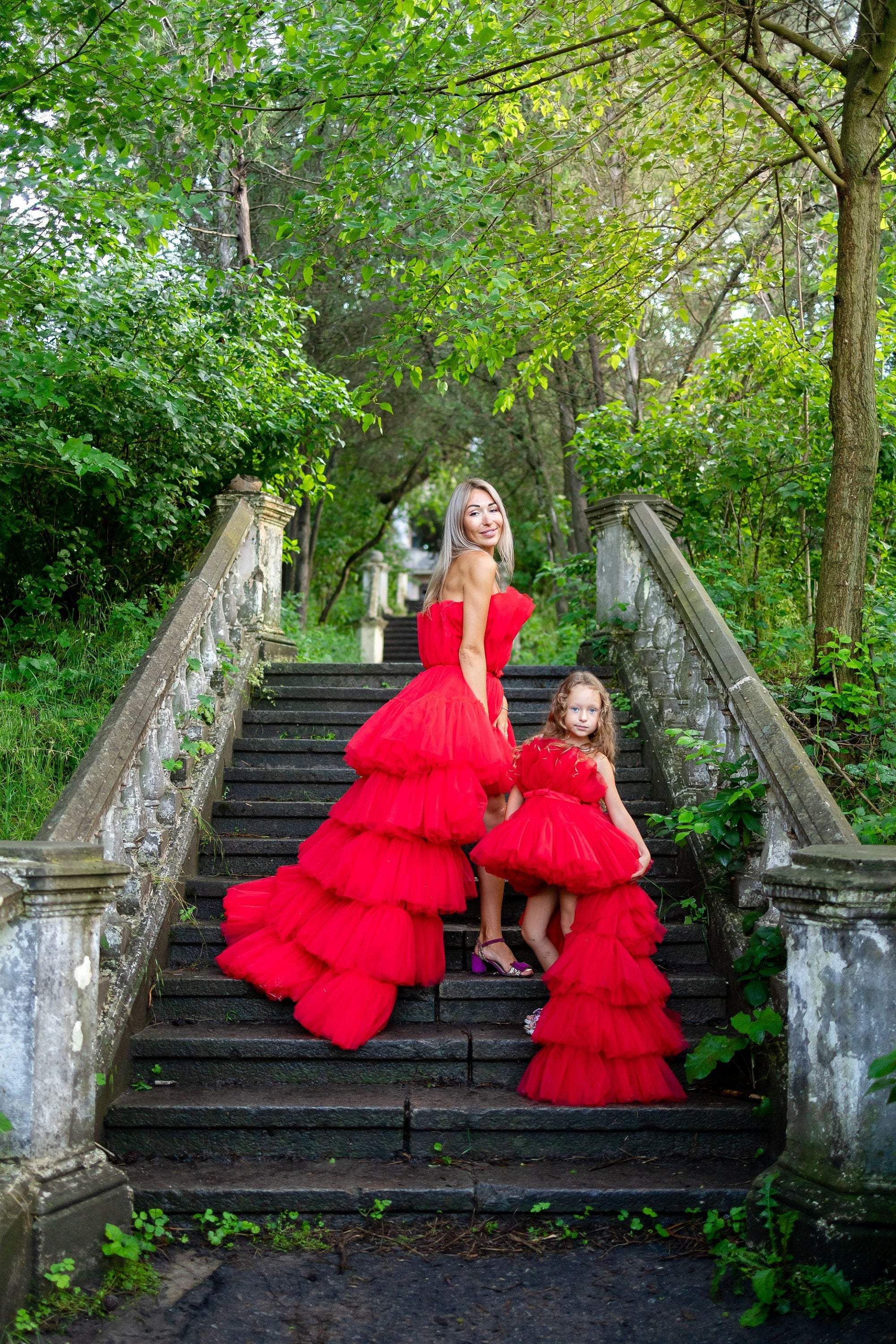 mother daughter red dresses Mother and daughter wearing matching red dresses outside a supermarket, 1950's. Source. PX Pixels